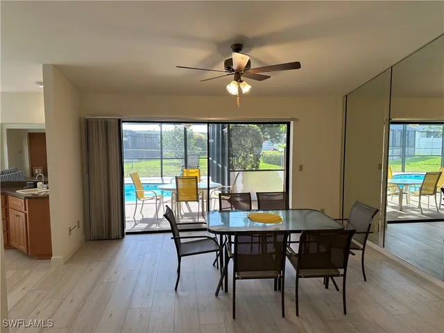 a dining room with furniture a chandelier and wooden floor