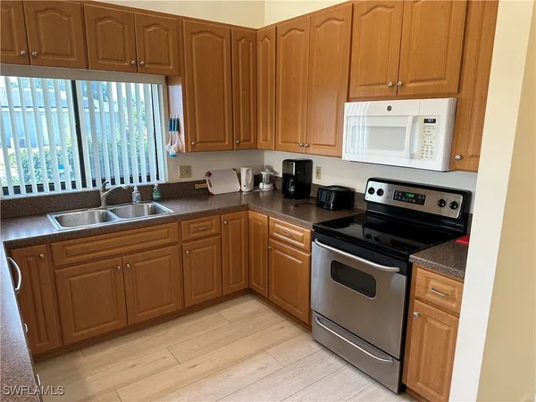 a kitchen with stainless steel appliances granite countertop a stove a sink and a microwave