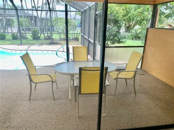 a view of a chairs and table in the back yard