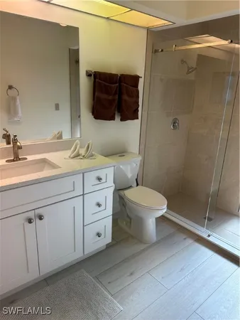 a bathroom with a granite countertop sink toilet and shower