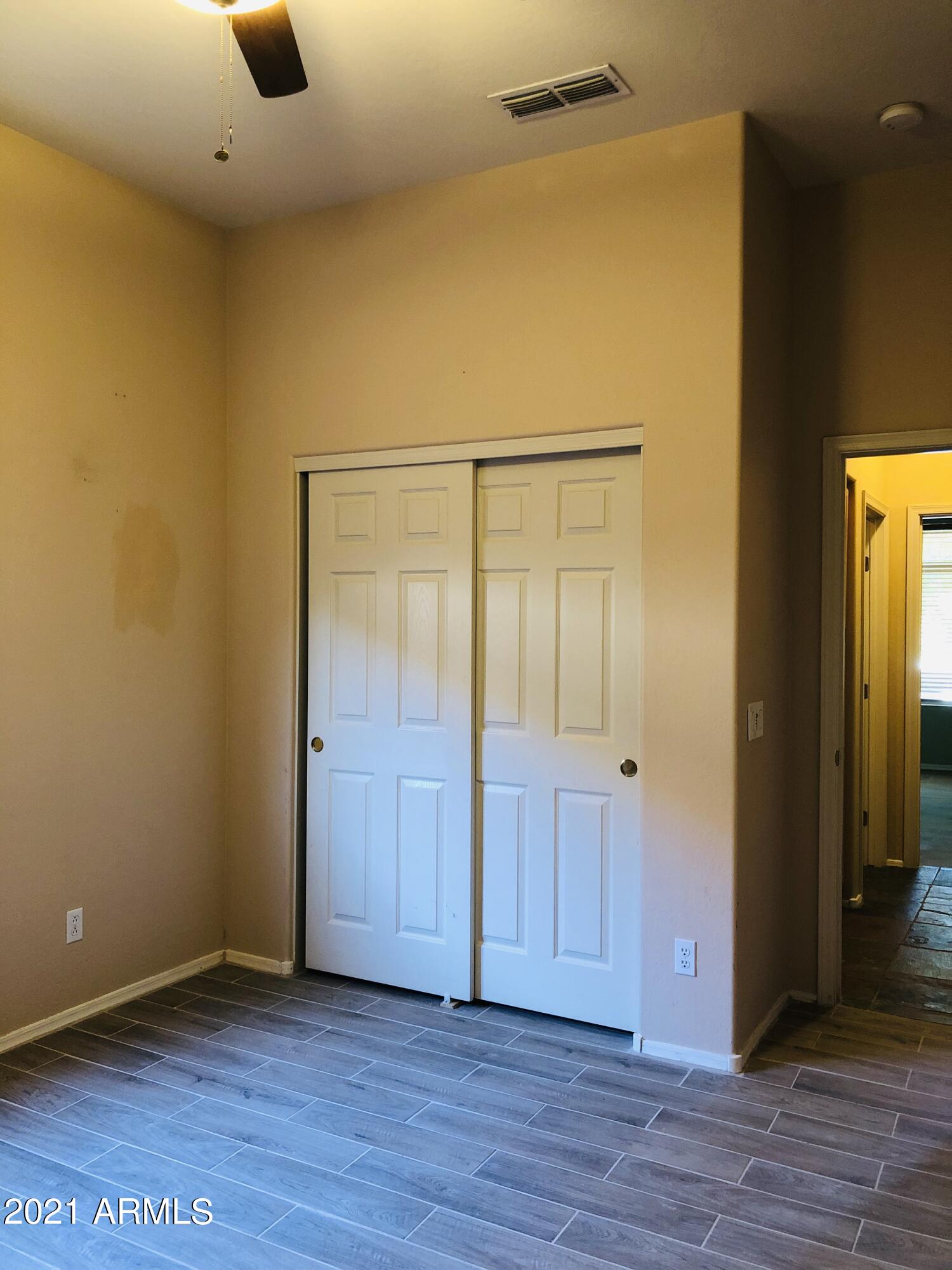 10453 East Pine Valley Drive Scottsdale, AZ 85255 - Photo 19 of 35 an empty room with wooden floor and windows