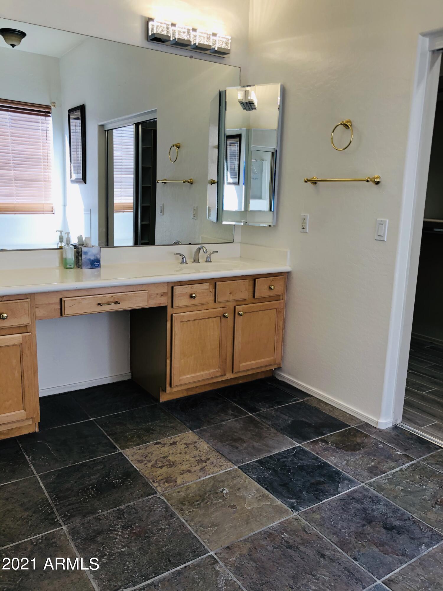 10453 East Pine Valley Drive Scottsdale, AZ 85255 - Photo 22 of 35 a spacious bathroom with a granite countertop sink a mirror and a