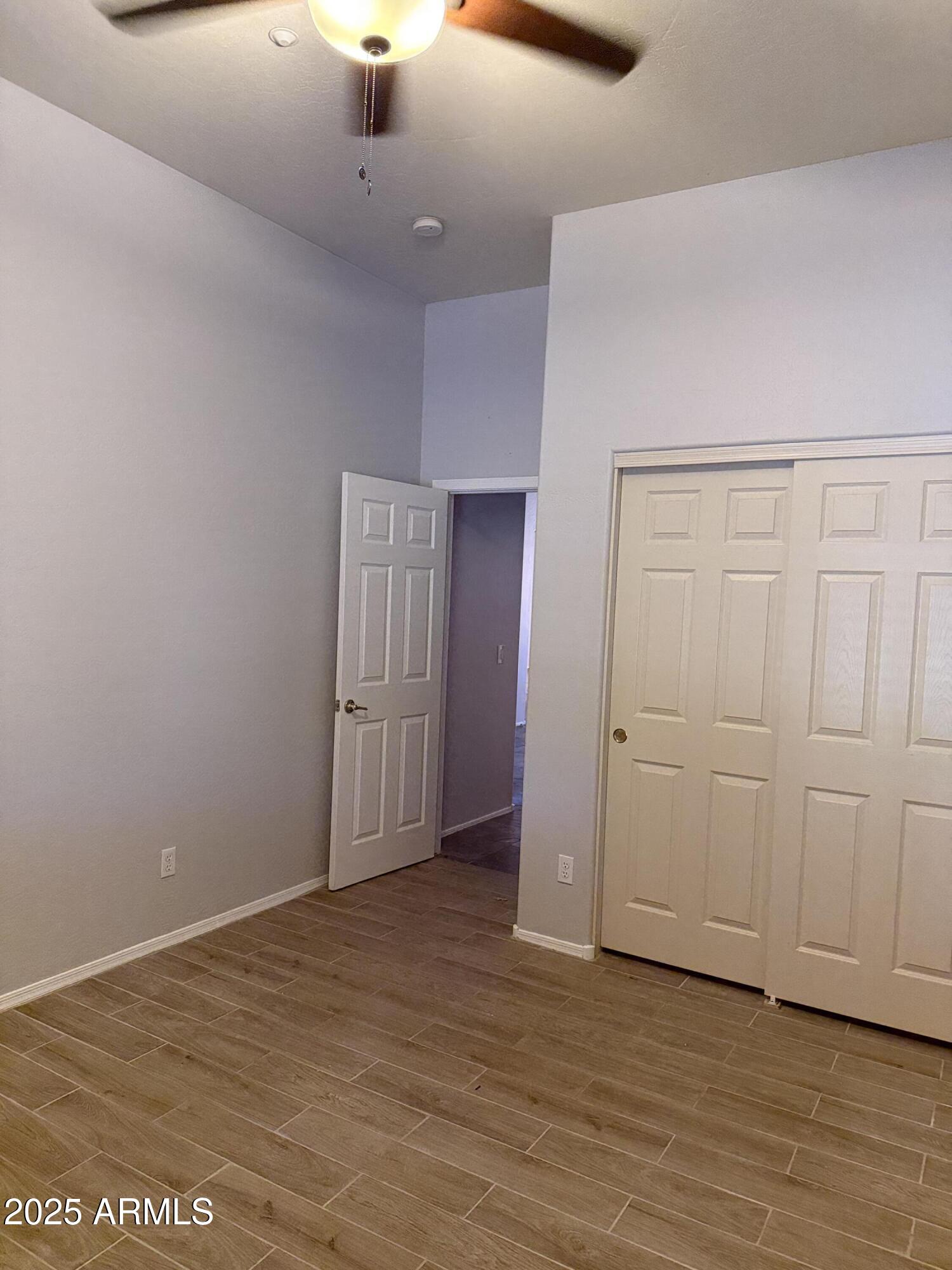 10453 East Pine Valley Drive Scottsdale, AZ 85255 - Photo 31 of 35 an empty room with wooden floor cabinet and windows