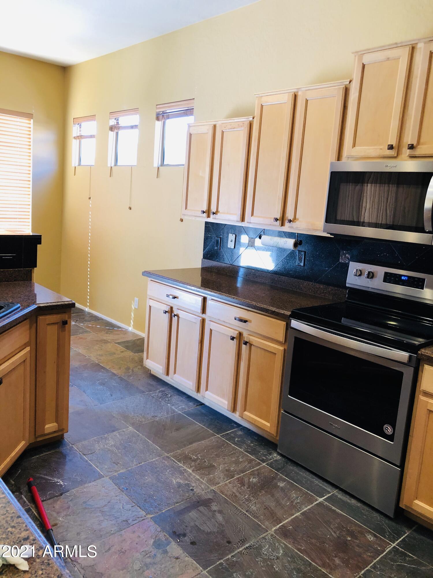 10453 East Pine Valley Drive Scottsdale, AZ 85255 - Photo 10 of 35 a kitchen with granite countertop a stove a sink and a microwave