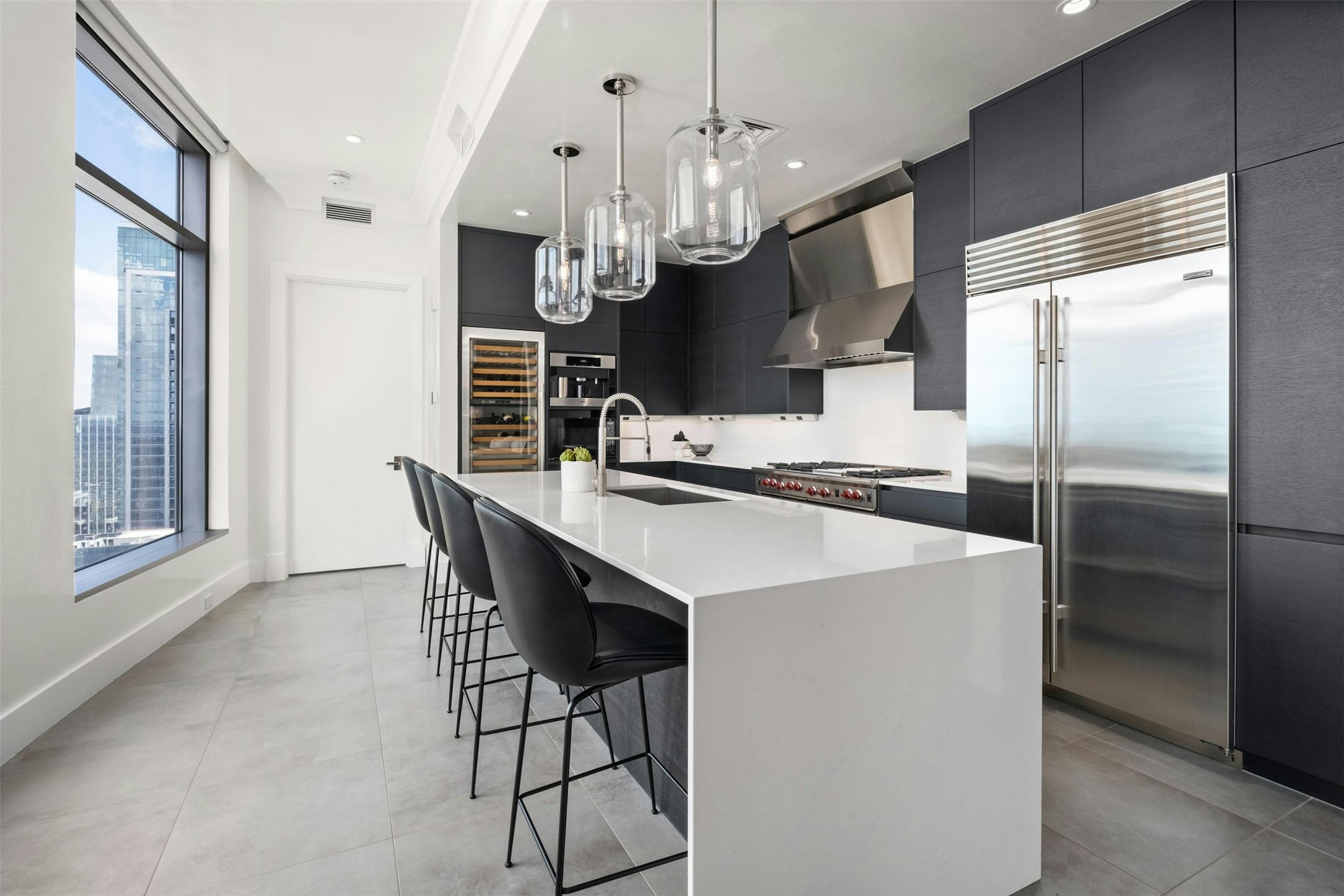 200 Congress Avenue, Unit 41Q Austin, TX 78701 - Photo 3 of 39 a kitchen with stainless steel appliances kitchen island a table chairs in it and wooden floors