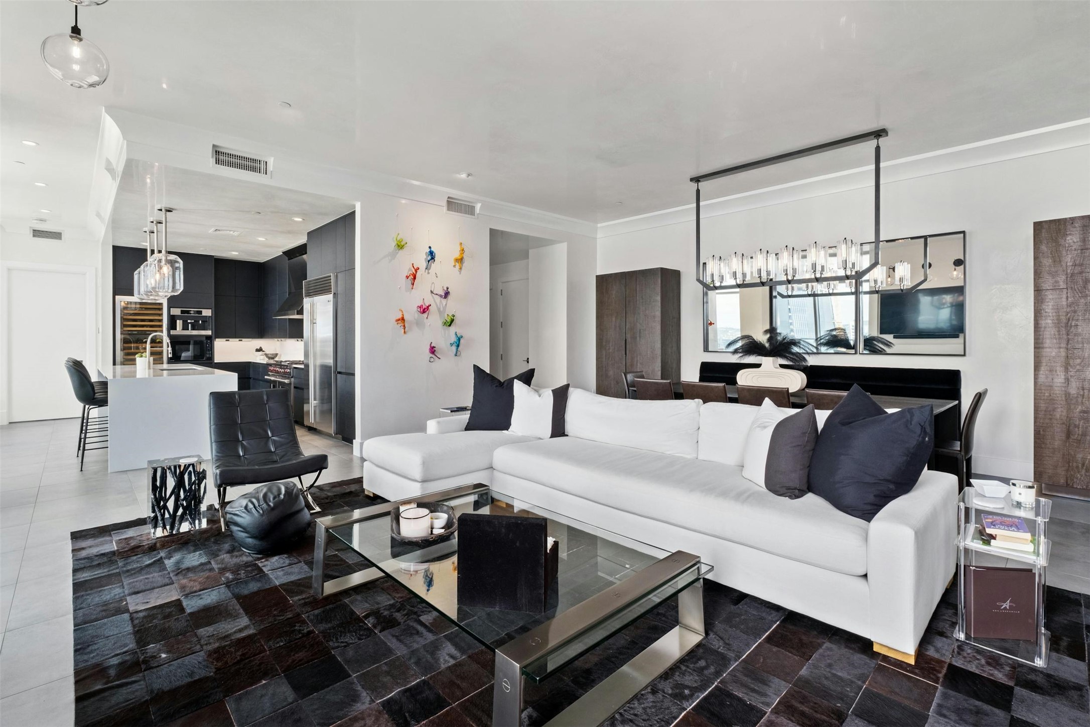 200 Congress Avenue, Unit 41Q Austin, TX 78701 - Photo 7 of 39 a kitchen with stainless steel appliances kitchen island granite countertop a sink dishwasher a refrigerator and white cabinets with wooden floor