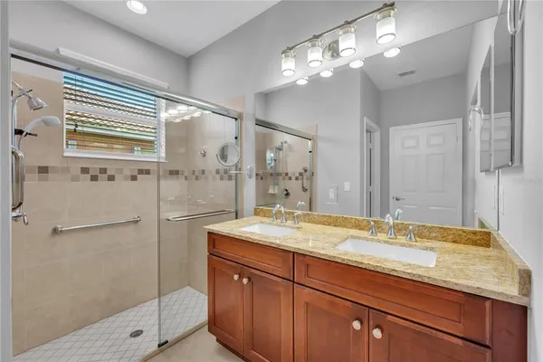 a bathroom with a granite countertop sink mirror and shower