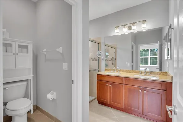 a spacious bathroom with a granite countertop sink a toilet and a shower