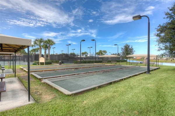 a view of a tennis ground with large trees
