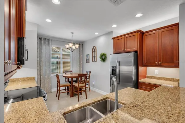 a kitchen with stainless steel appliances granite countertop sink refrigerator and cabinets