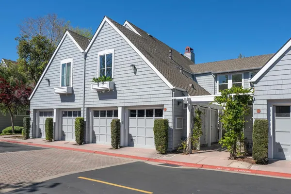 a view of a white house with palm trees