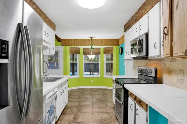 a bathroom with a granite countertop sink and a large mirror
