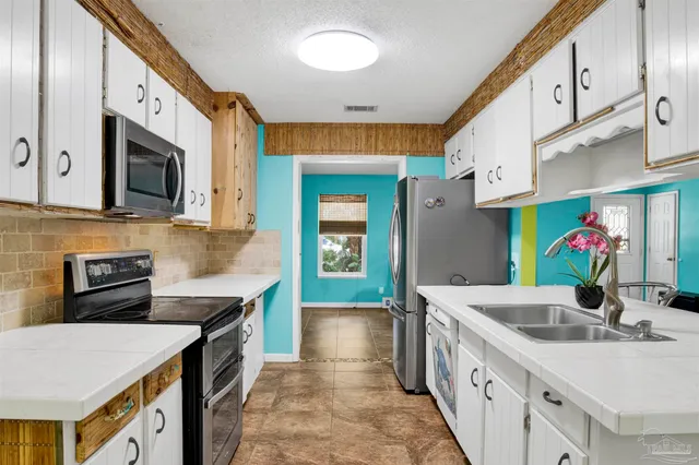 a kitchen with stainless steel appliances a sink dishwasher stove refrigerator and microwave