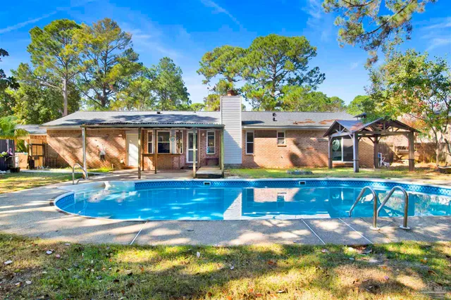a view of a house with swimming pool and sitting area