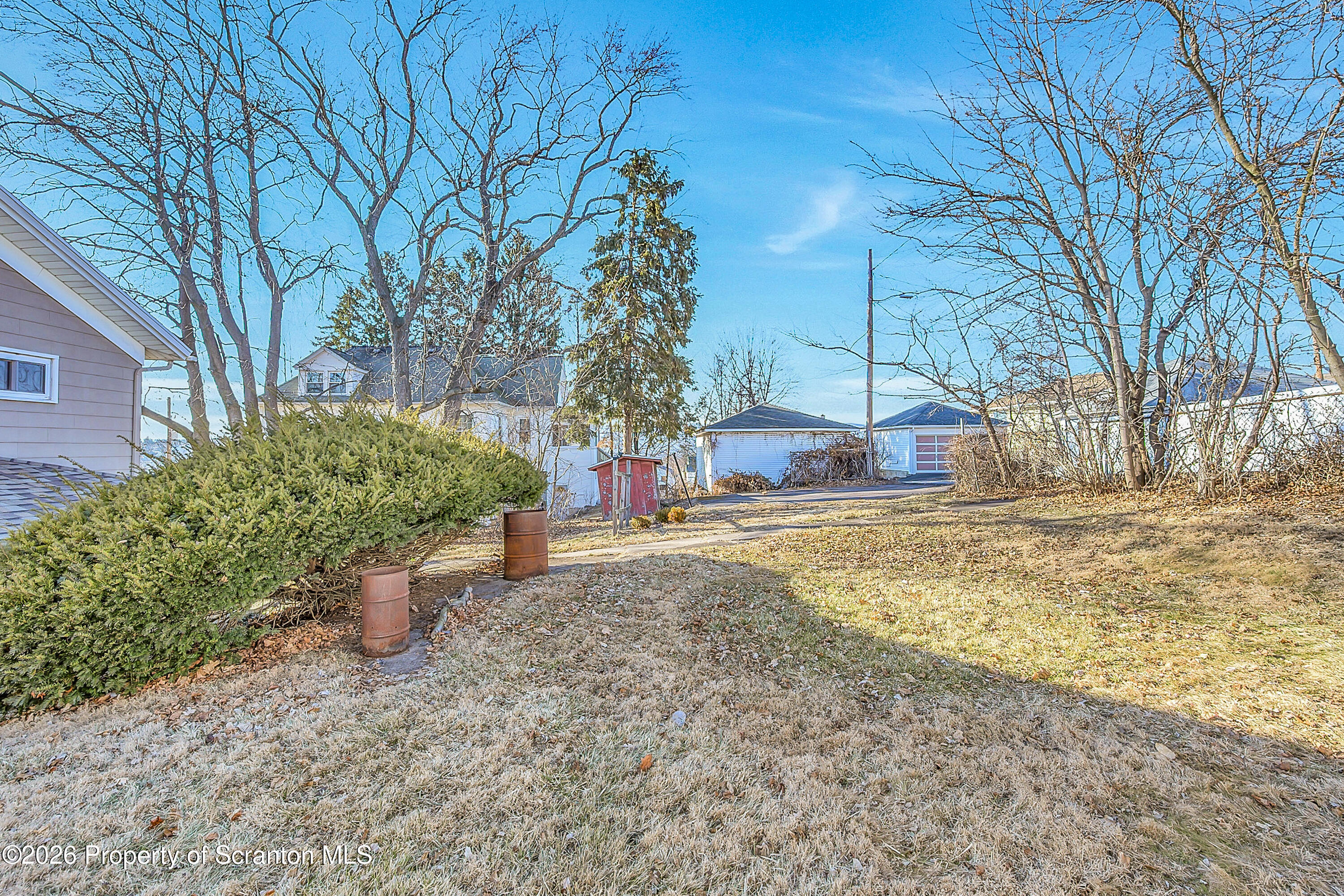 331 Cherry Street, Unit A Dunmore, PA 18512 - Photo 3 of 18 a backyard of a house with large trees and covered with snow