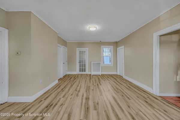 an empty room with wooden floor and closet