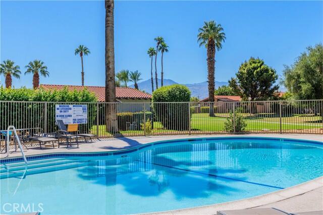 82151 Waring Way, Unit 33 Indio, CA 92201 - Photo 16 of 17 a view of a swimming pool with a lounge chairs