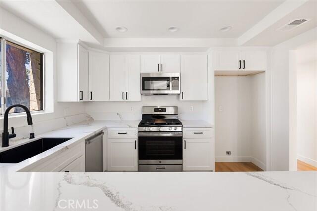 82151 Waring Way, Unit 33 Indio, CA 92201 - Photo 5 of 17 a kitchen with stainless steel appliances a stove a sink and a refrigerator