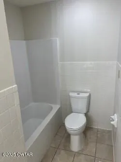 a white toilet sitting next to a white sink