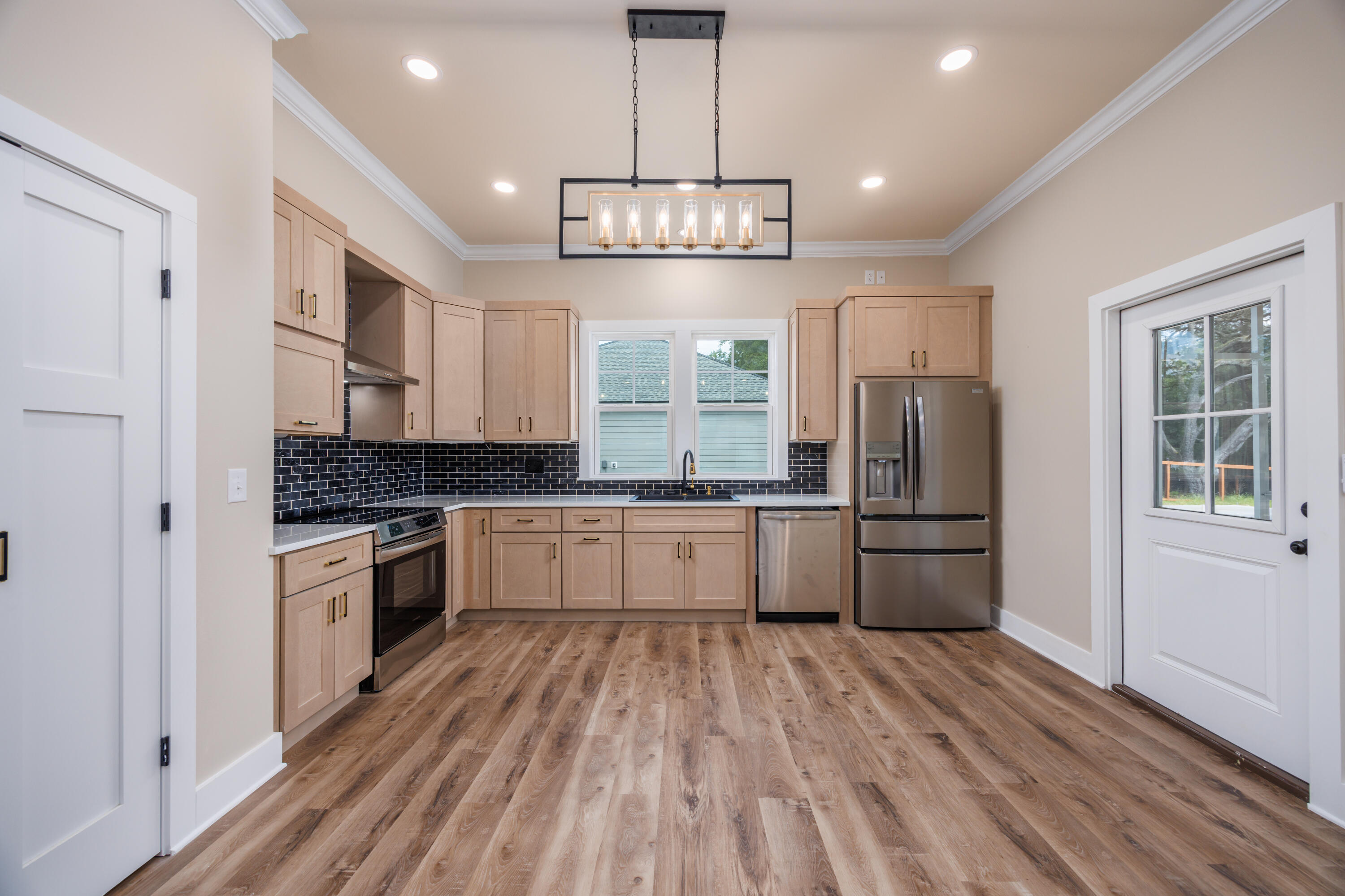 14 Shebbi Lane Freeport, FL 32439 - Photo 6 of 25 a large kitchen with stainless steel appliances granite countertop a refrigerator a stove a sink dishwasher a dining table and chairs with wooden floor