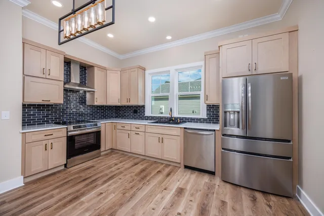 a kitchen with granite countertop a refrigerator stove top oven and sink