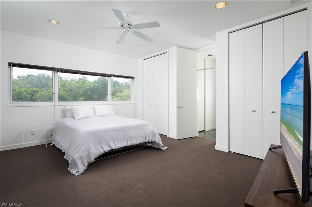 427 Ridge Court Naples, FL 34108 - Photo 20 of 49 a spacious bedroom with a bed and a flat tv screen