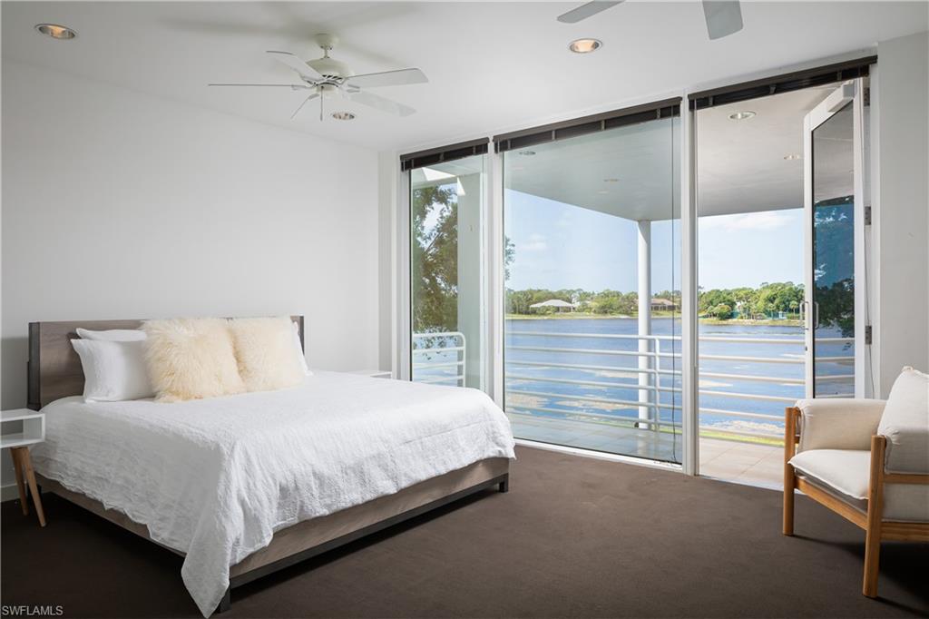 427 Ridge Court Naples, FL 34108 - Photo 21 of 49 a bedroom with a large bed and a chandelier