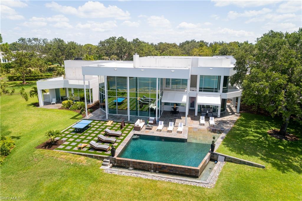 427 Ridge Court Naples, FL 34108 - Photo 36 of 49 a view of a swimming pool with a patio and a garden