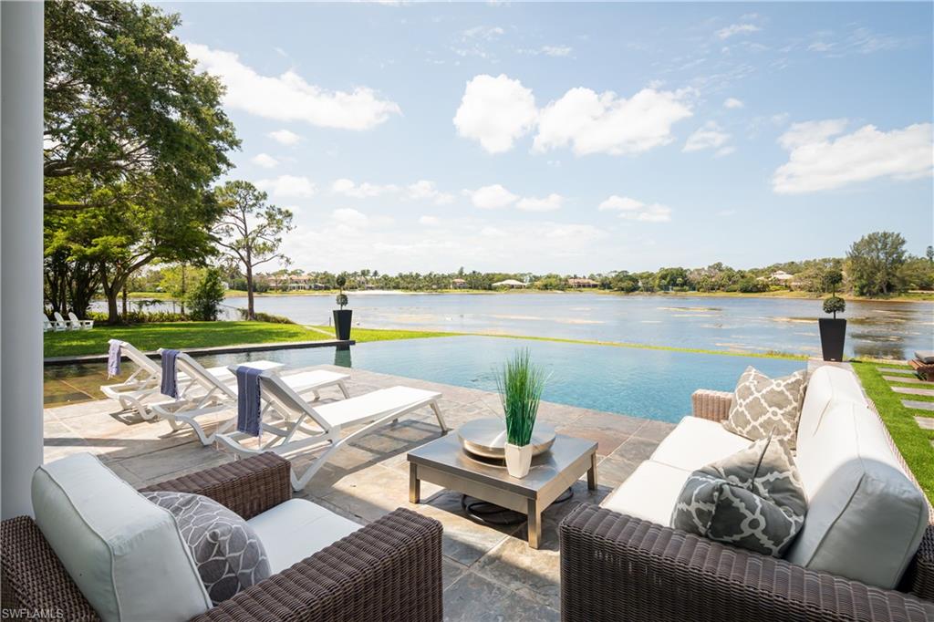 427 Ridge Court Naples, FL 34108 - Photo 39 of 49 a view of a patio with couches chairs and a table and chairs with the ocean view