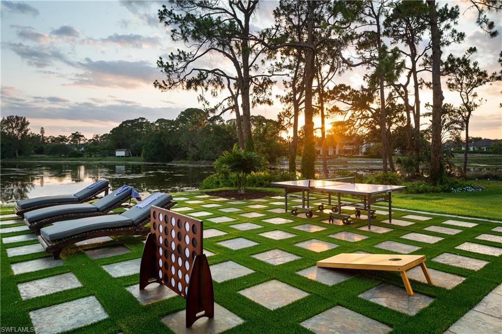 427 Ridge Court Naples, FL 34108 - Photo 41 of 49 a view of a lake with couches and wooden fence