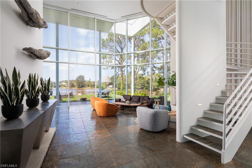 427 Ridge Court Naples, FL 34108 - Photo 5 of 49 a living room with furniture a flat screen tv and a floor to ceiling window
