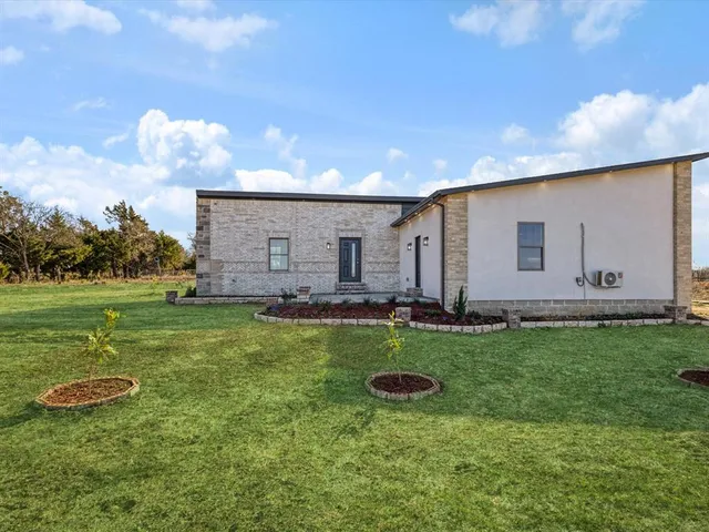 a backyard of a house with table and chairs