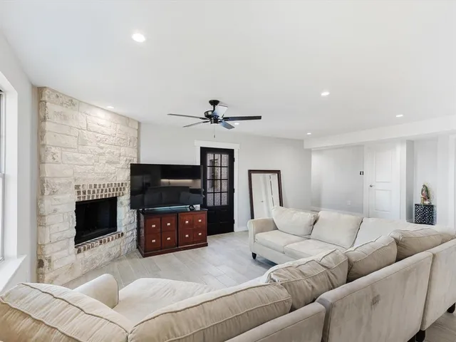 a living room with furniture a flat screen tv and a fireplace