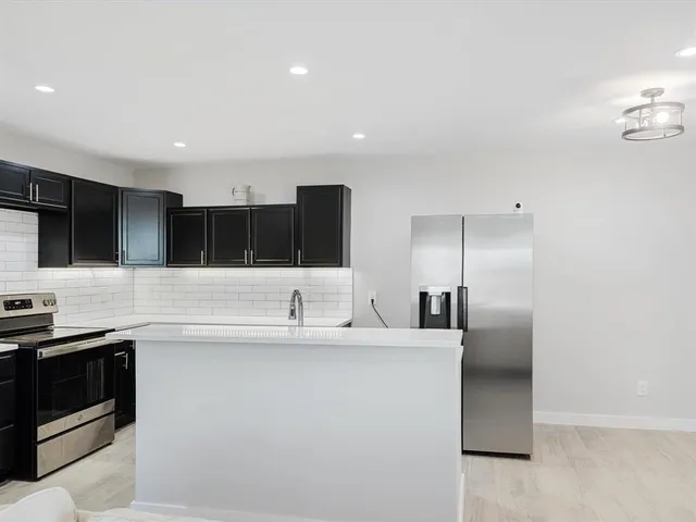 a kitchen with stainless steel appliances a sink a stove a microwave a counter top and oven