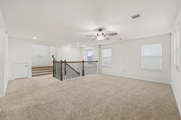 an empty room with a window and a fan