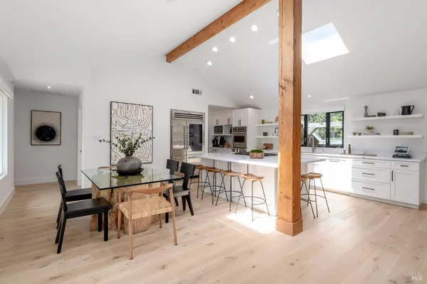a large white kitchen with cabinets a sink and a stove