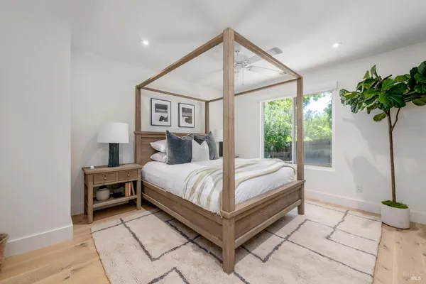 a spacious bathroom with a double vanity sink large mirror bathtub and window