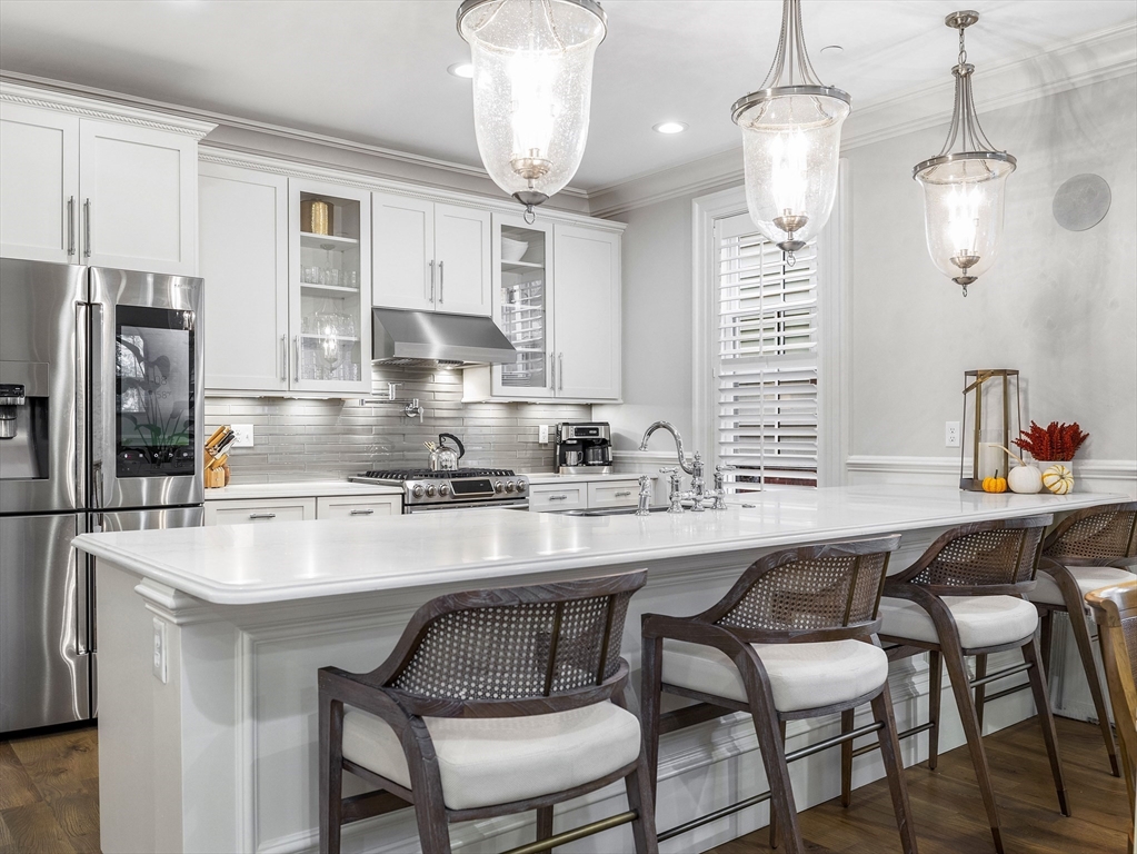 a kitchen with a dining table chairs cabinets and stainless steel appliances