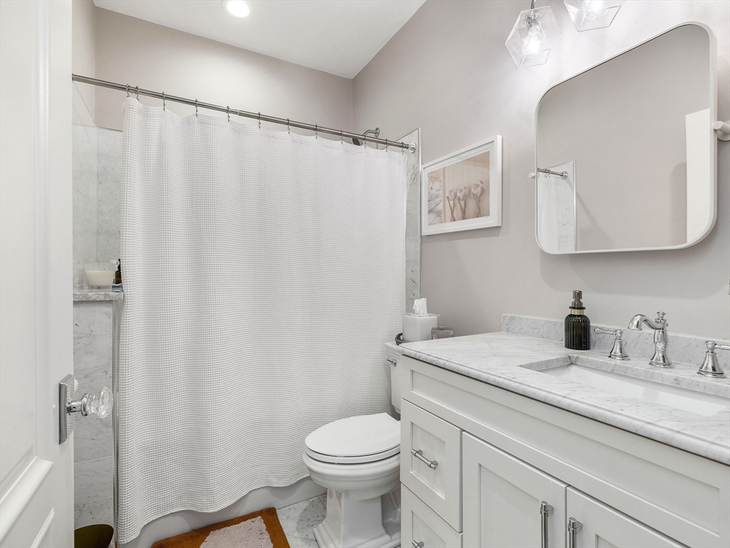 711 East 2nd Street, Unit 2 Boston, MA 02127 - Photo 9 of 25 a bathroom with a granite countertop sink toilet and a mirror