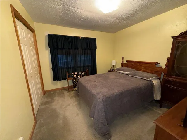 a bed sitting in a bedroom and closet with a mirror