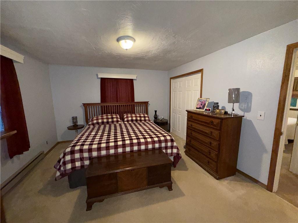 1637 Highway 981 Ruffs Dale, PA 15679 - Photo 7 of 11 a bedroom with a bed and a flat tv screen on wall