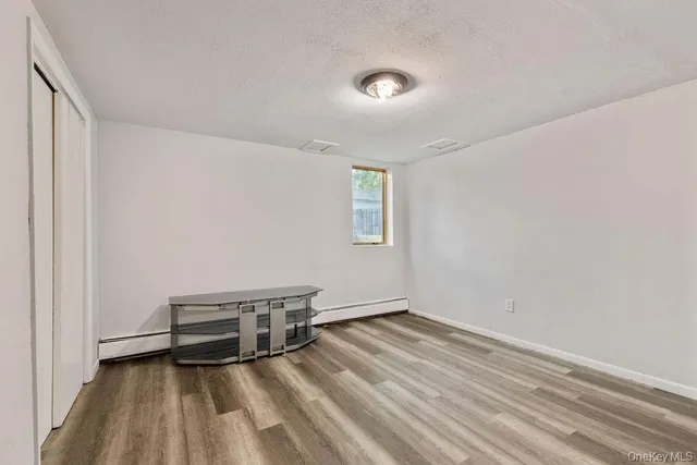 a view of a room with wooden floor and white walls