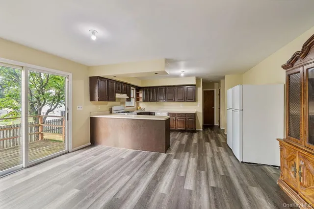 a kitchen with a refrigerator sink and wooden cabinets