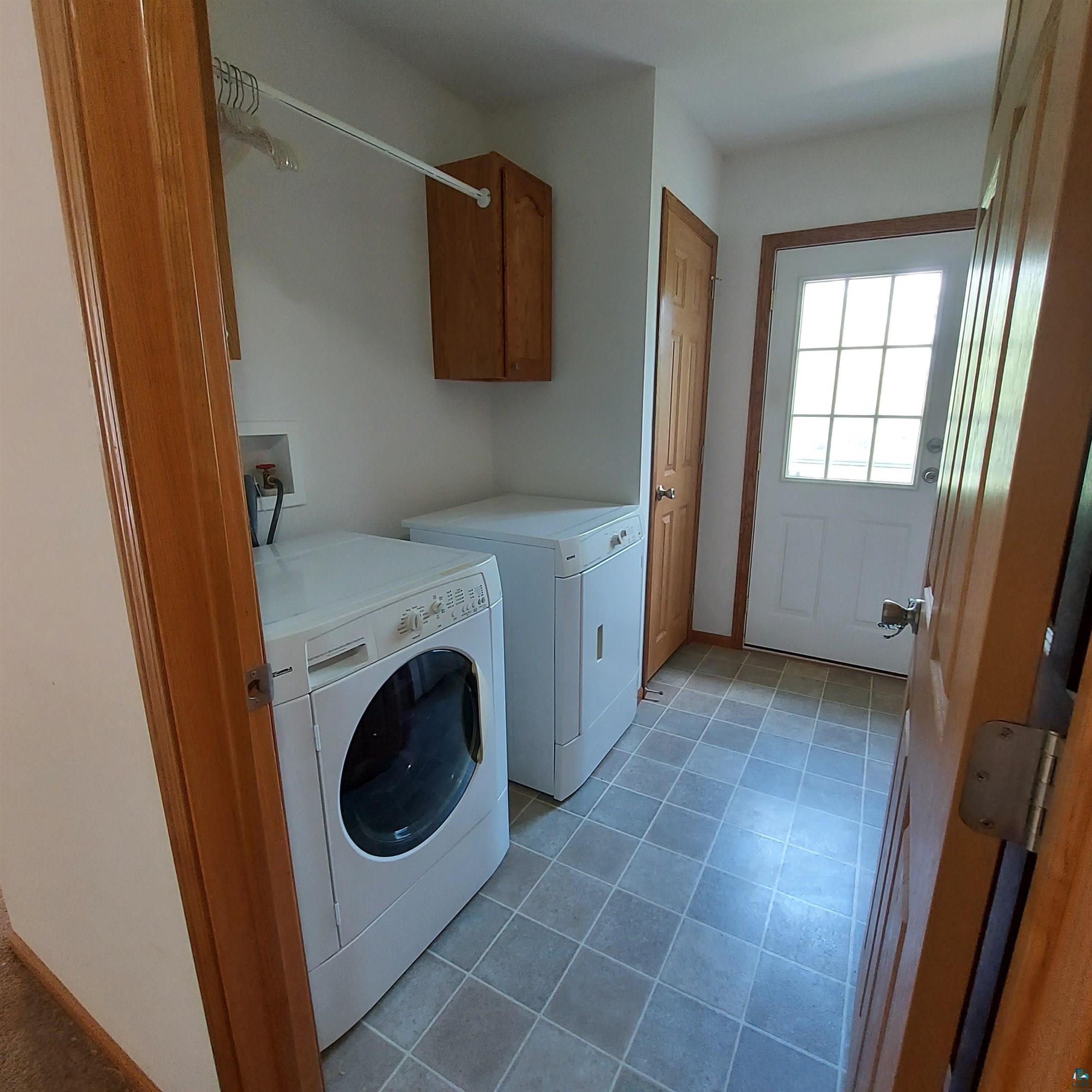 6563 Seville Road Saginaw, MN 55779 - Photo 16 of 28 Laundry area with washer and clothes dryer, cabinets, and light tile patterned floors