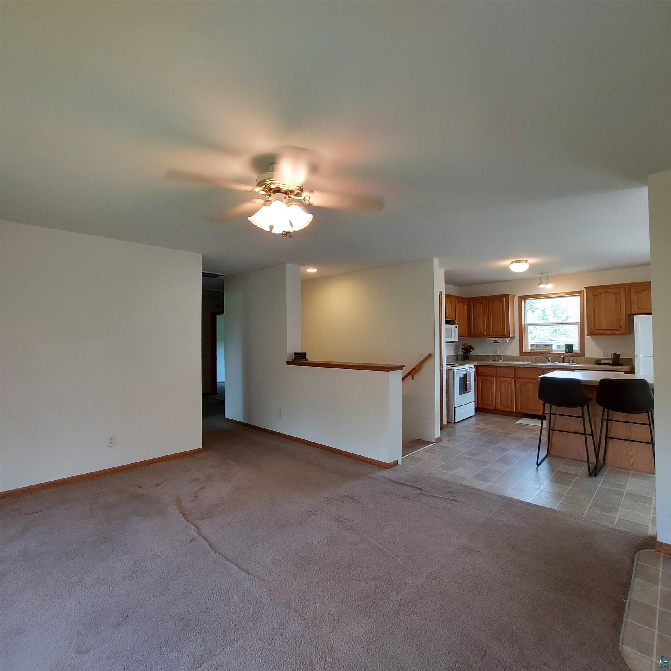 6563 Seville Road Saginaw, MN 55779 - Photo 9 of 28 Unfurnished living room featuring sink, light carpet, and ceiling fan