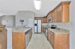 1664 Portsmouth Lake Drive Brandon, FL 33511 - Photo 11 of 38 a large kitchen with stainless steel appliances granite countertop a sink stove and refrigerator