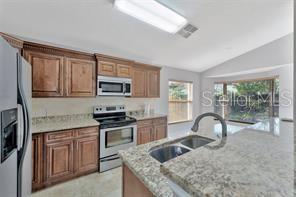 1664 Portsmouth Lake Drive Brandon, FL 33511 - Photo 14 of 38 a kitchen with a stove a sink and a microwave