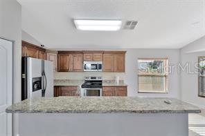 1664 Portsmouth Lake Drive Brandon, FL 33511 - Photo 7 of 38 a kitchen with stainless steel appliances granite countertop a stove a sink and a microwave