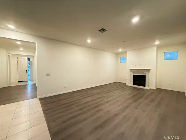 an empty room with wooden floor and fireplace