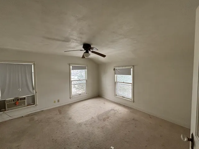 an empty room with windows and cabinet